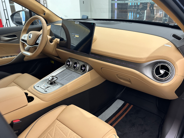 Das Innere eines Mercedes-Benz S-Klasse Limousines auf der Internationalen Automobil-Ausstellung in Frankfurt, mit Lenkrad, Armaturenbrett, Bildschirmen, Knöpfen, Sitzen, Seitenspiegeln und Glasfenstern, durch die Menschen, Gebäude und andere Objekte im Hintergrund zu sehen sind.