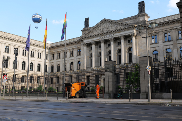 Großes modernes Gebäude mit vielen Fenstern, als Bundestag in Berlin, Deutschland identifiziert, umgeben von Straßeninfrastruktur und Fußgängern.