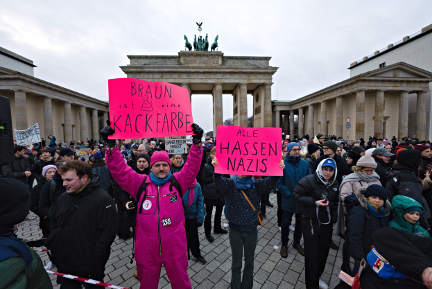 Gruppe von Demonstranten protestiert vor dem Brandenburger Tor in Berlin mit Schildern gegen die Anti-Nazis-Bewegung der deutschen Regierung.