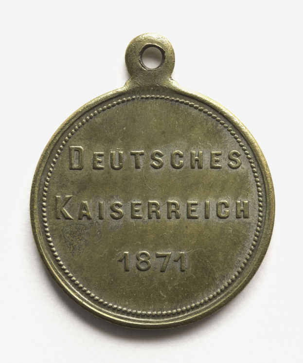 Bronzene Medaille mit der Inschrift "Deutsches Kaiserreich 1871" vor einem weißen Hintergrund.