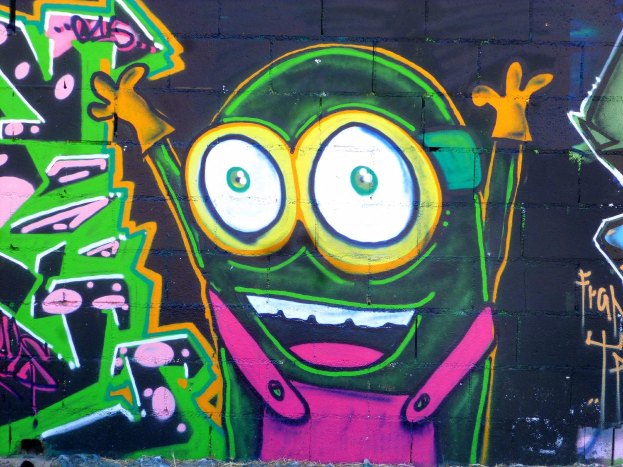 Bunt bemalter Cartoon-Graffiti-Charakter auf einer Wand.