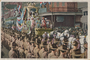 Eine alte Postkarte zeigt einen Mardi Gras-Umzug in New Orleans mit einem geschmückten Festwagen, Reiter und Zuschauern auf der Straße sowie Gebäuden im Hintergrund und der Beschriftung "The Rex Float, Mardi Gras Carnival, New Orleans" unten.