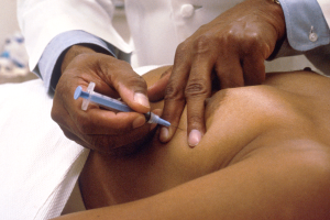 Ein Arzt in einem weißen Kittel verpasst einem Patienten eine Spritze.