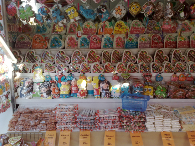 Candy shop display case with various candies, toys, and objects arranged in a rack, each with price tags.