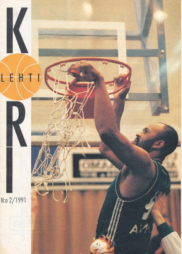 Ein Basketballspieler in dunkler Uniform dunkt den Ball in den Korb, während sich eine andere Person in der Nähe befindet, mit einem Netz im Hintergrund und einer Wand dahinter; Text links lautet "Kobe Bryant 1991-92 Basketballkarte."