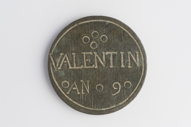 Eine Münze mit dem Wort "Valentin" darauf vor einem weißen Hintergrund.