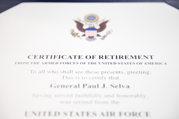 Rahmenurkunde für den Ruhestand der United States Air Force mit blauem Rand, die ein schwarzes Textfeld, ein zentrales Sternsymbol innerhalb eines Lorbeerkranzes und ein Banner mit der Aufschrift "Ruhestand" zeigt.