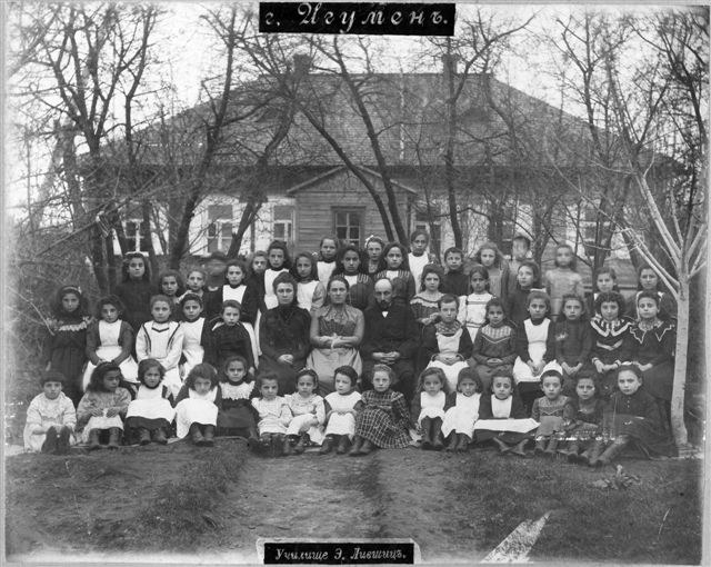 Schwarzes und weißes Foto einer Gruppe von Kindern, die vor einem Fensterbau mit Text "Jugoslawien, die erste Schule der Welt" posieren.